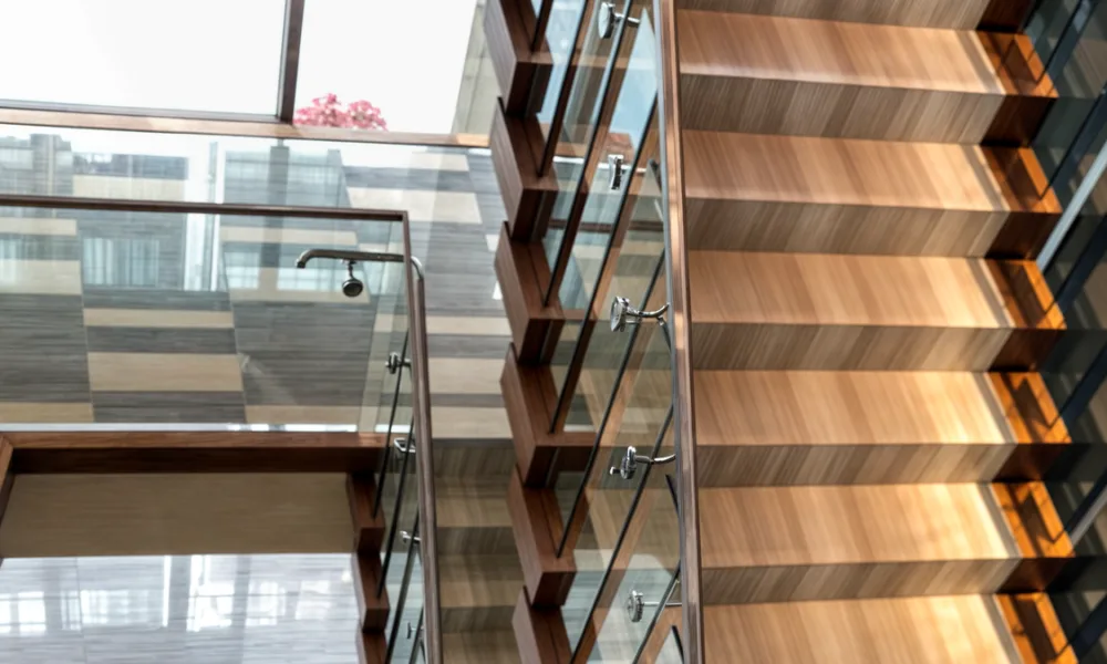 Side-mounted glass railings preserve usable space on stairs and balconies by moving the supporting channel or fittings to the vertical face of the structure.