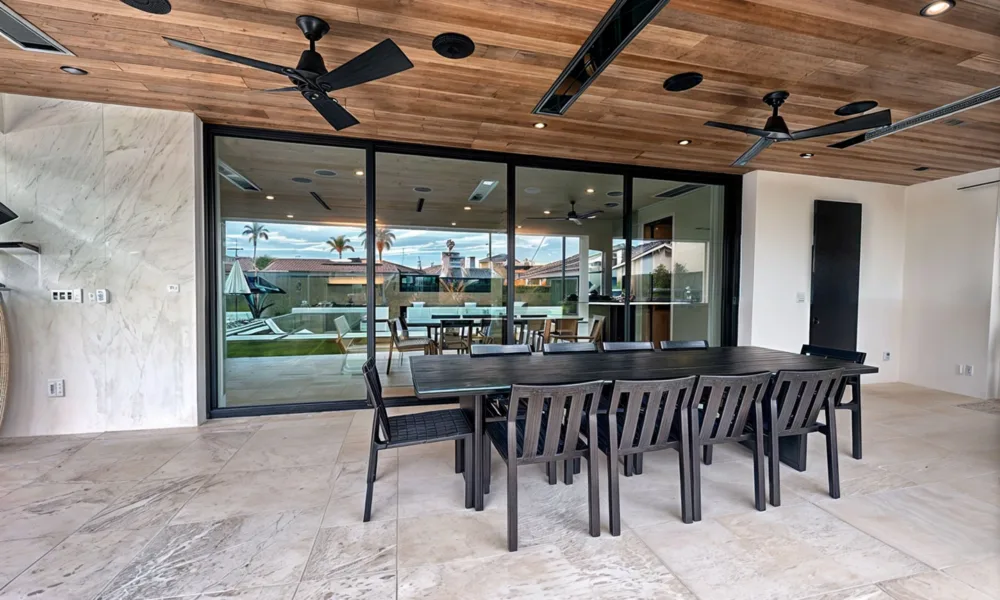 A small living room can feel significantly larger when natural light enters through a wide glass opening, extending the view toward a patio, garden, or outdoor area.
