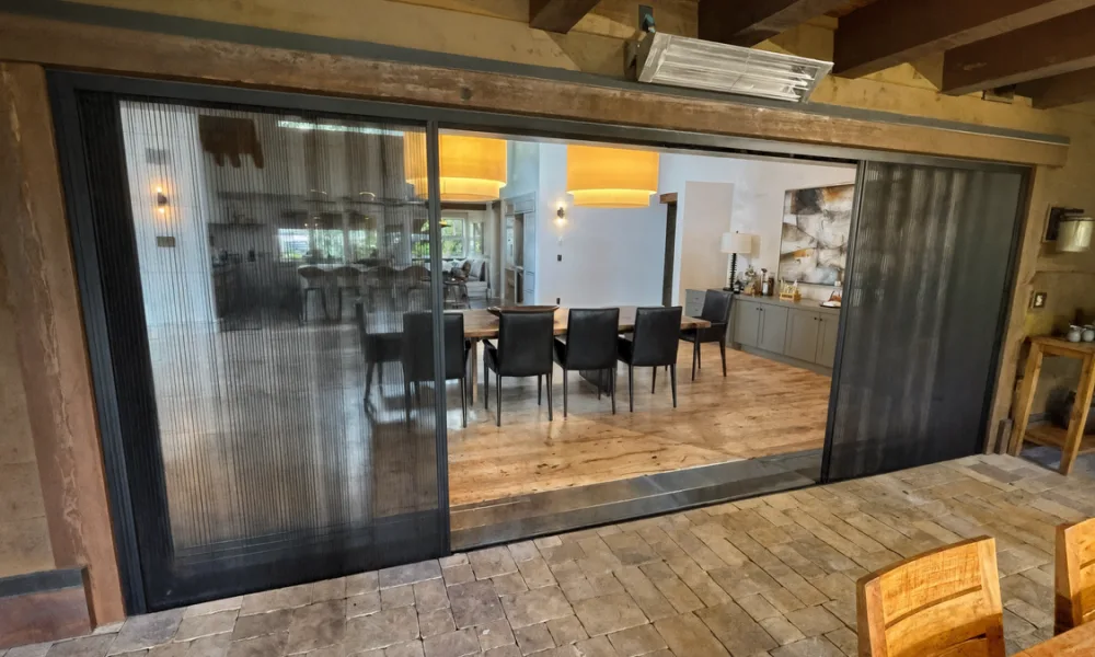In a top-hung sliding system, panel loads pass through the carriers and head track to the header and its supports. The floor guide does not carry the primary panel weight.